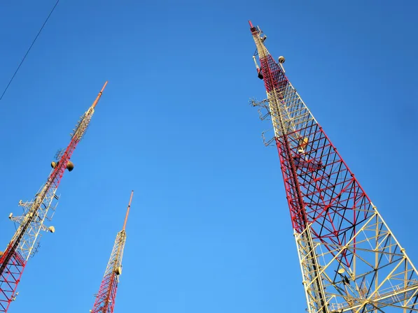 Torres de telecomunicaciones elevándose sobre un cielo azul.